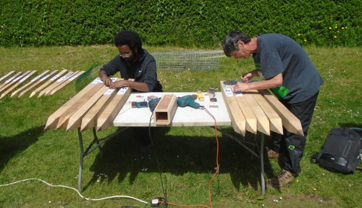 Volunteers Abdul and Jo fixing QR codes to the Marker Posts