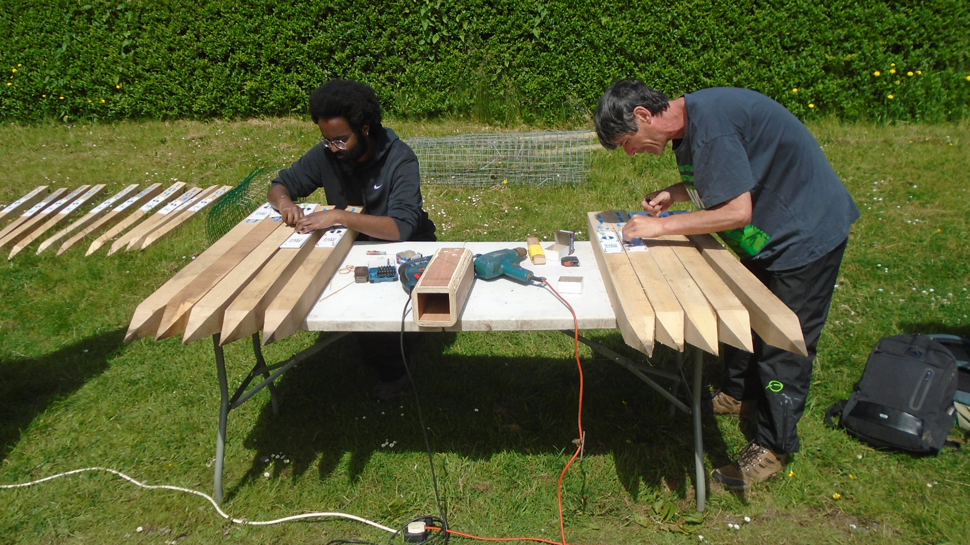 Volunteers Abdul and Jo fixing QR codes to the Marker Posts